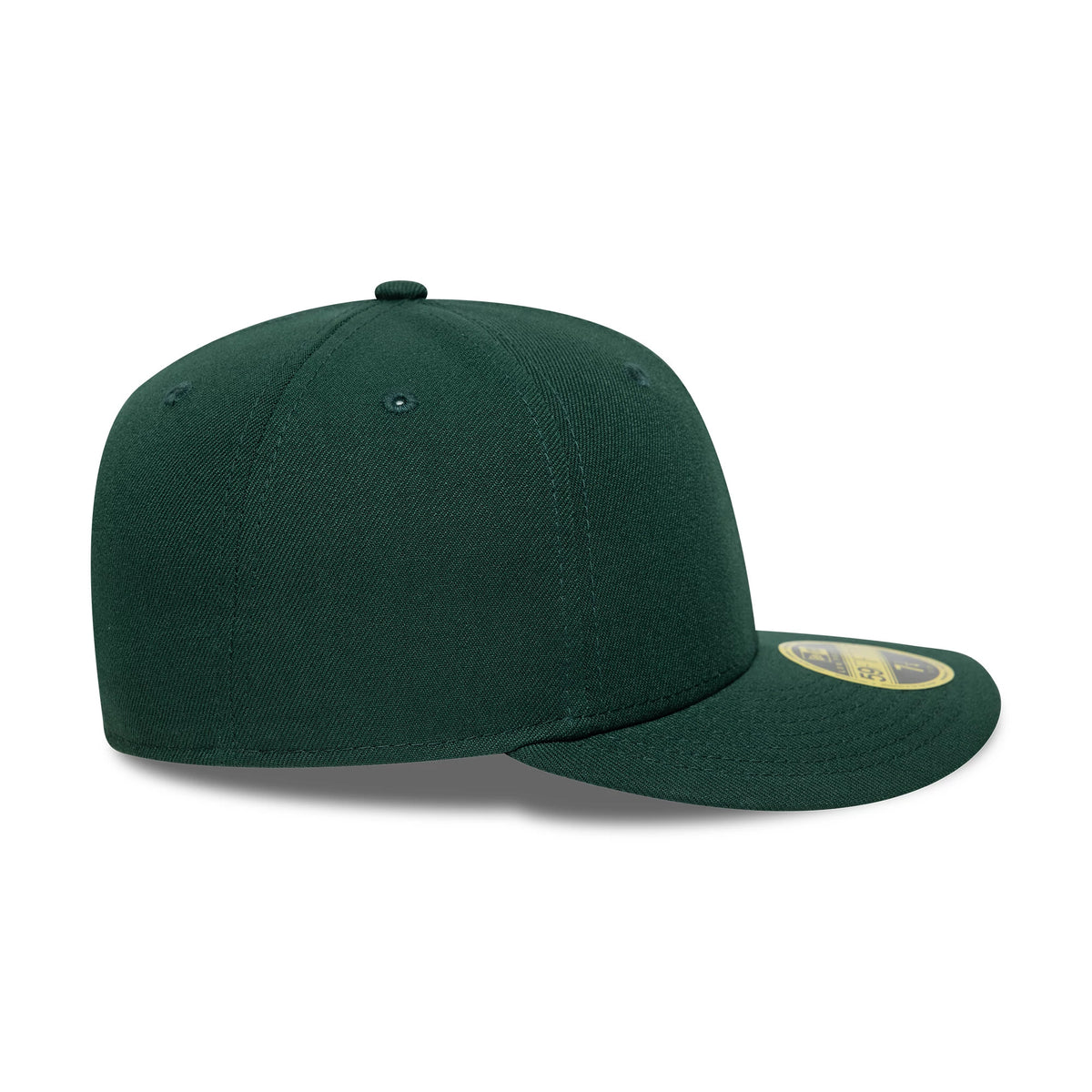 New Era Dark Green Low Profile 59FIFTY Fitted Cap, side view showing the structured dark green crown with embroidered eyelets and a matching top button, and a flat visor with a gold 59FIFTY size sticker on the upper side.