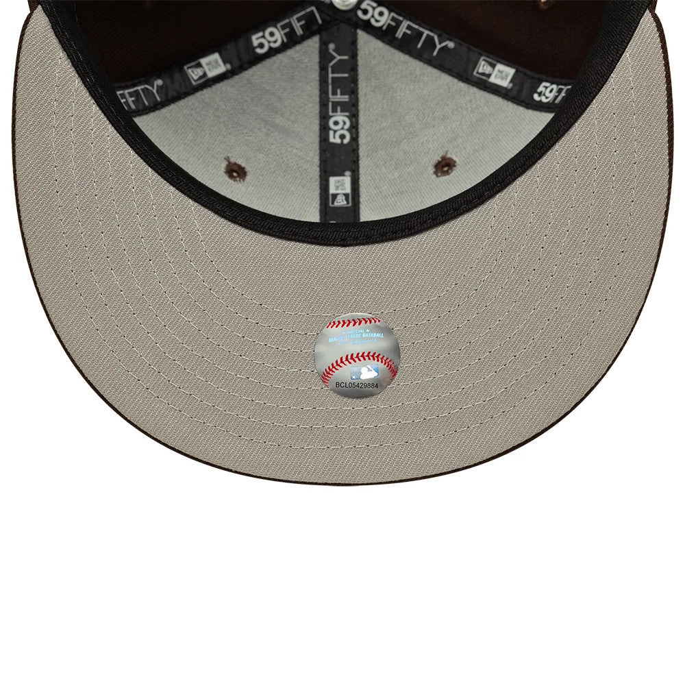 New York Yankees MLB Dark Brown New Era 59FIFTY Fitted Cap, inside view showing black taping with 59FIFTY branding, a grey sweatband, and a baseball sticker on the khaki undervisor, providing detailed craftsmanship and design elements inside the cap.
