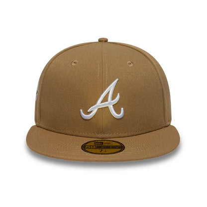 Atlanta Braves MLB Sidepatch Beige New Era 59FIFTY Fitted Cap, front view showing a raised white embroidered A logo on the centre of the structured beige crown, with a gold 59FIFTY size sticker on the flat beige visor.