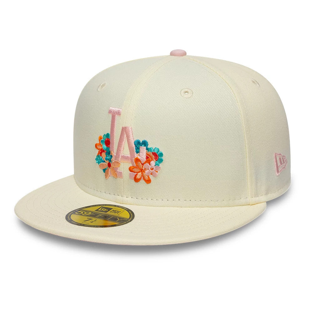 LA Dodgers MLB Floral Cream New Era 59FIFTY Fitted Cap, three-quarter view showing the pastel pink embroidered LA logo with colourful floral details on the front panel, cream visor, and a pink embroidered New Era flag logo on the left side.