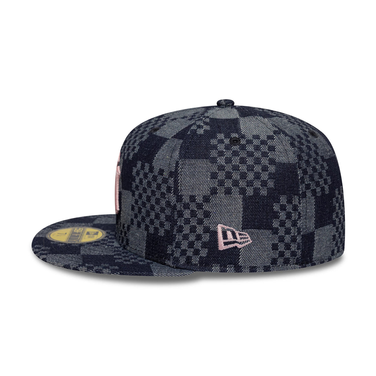 New York Yankees MLB Denim Blue New Era 59FIFTY Fitted Cap, side view showing a pink embroidered New Era flag logo on a dark blue and grey checkered patterned crown and visor, with a gold 59FIFTY size sticker on the flat visor.