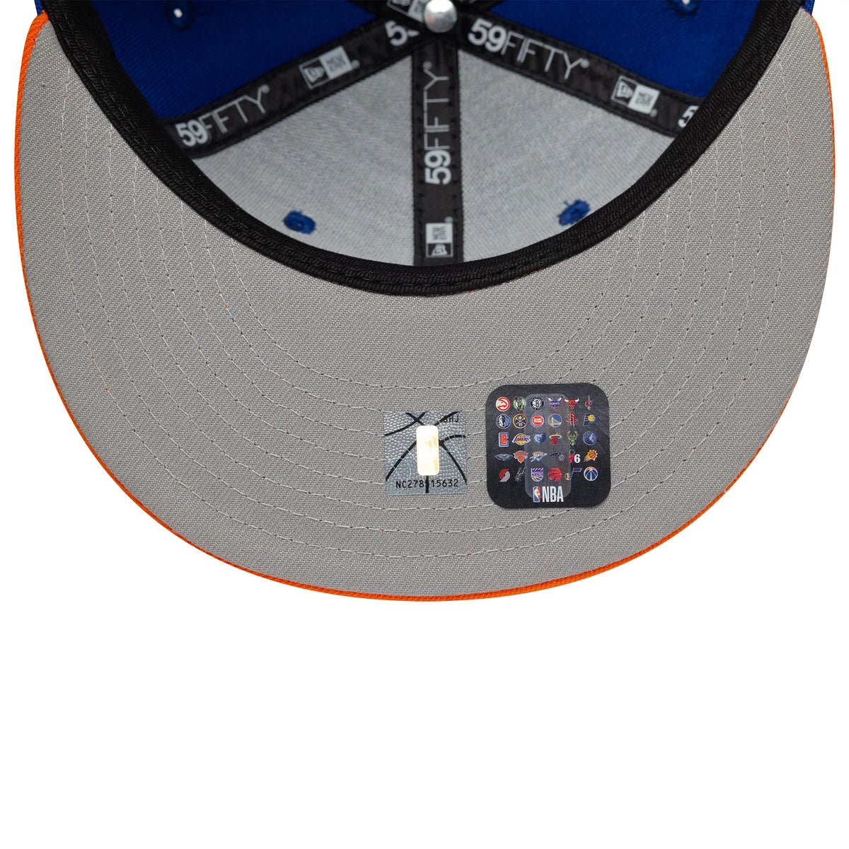 Pictured is this NBA Champs 2025 - 2026 New York Knicks 59FIFTY Fitted cap in blue and orange. 2
