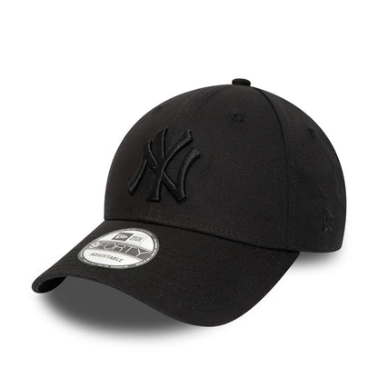 New York Yankees Essential Black on Black New Era 9FORTY Cap, three-quarter view showing a raised black NY logo embroidered on the front panel, a curved black visor with a 9FORTY size sticker, and the New Era flag logo on the left side.