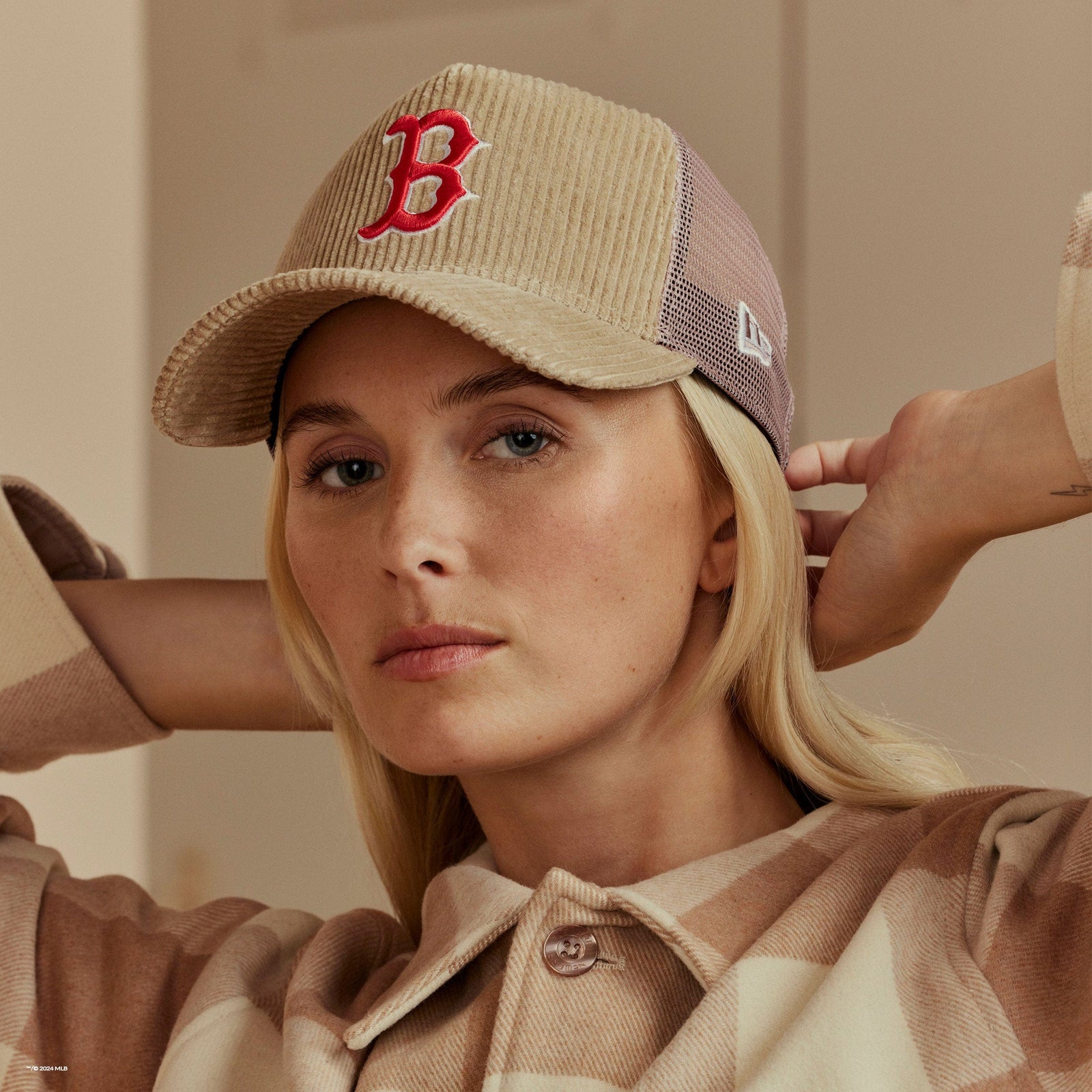 woman wearing a plaid beige shacket with a beige cap
