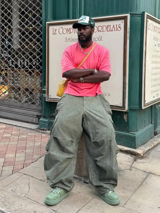 Slide 3:Man wearing bright pink t-shirt, baggy cargo pants, and a new era cap