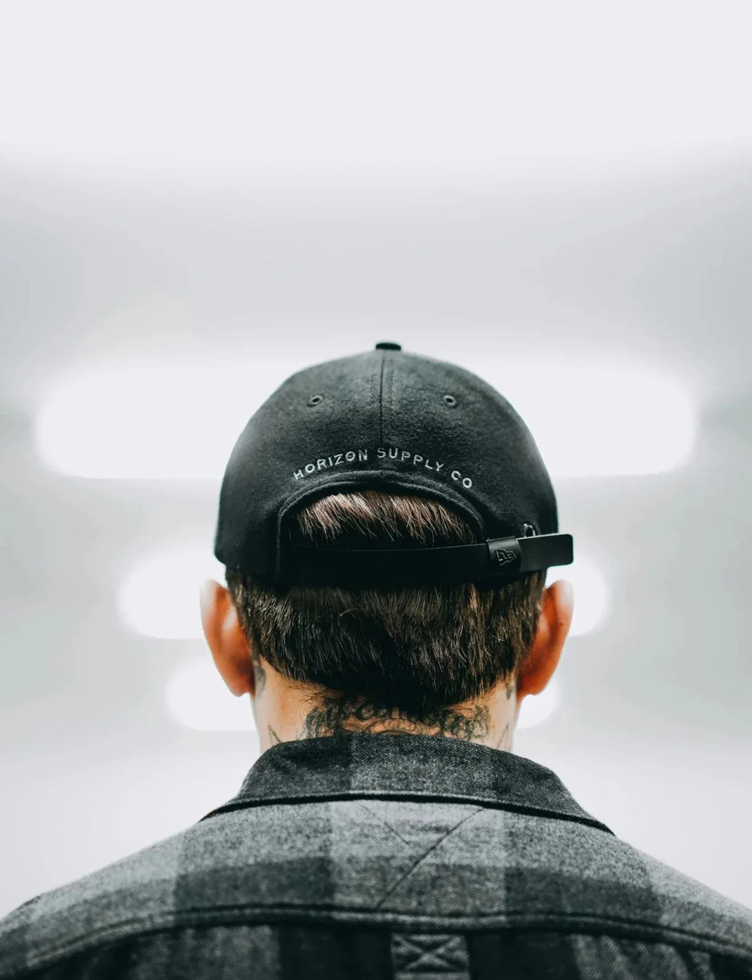 Person wearing a black cap with 'Horizon Supply Co' logo on a blurred background