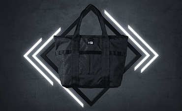 black new era holdall bag against lit background 