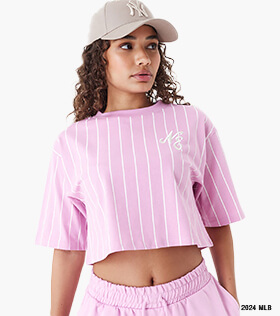 woman wearing a new era branded pink stripey crop top with matching pink shorts